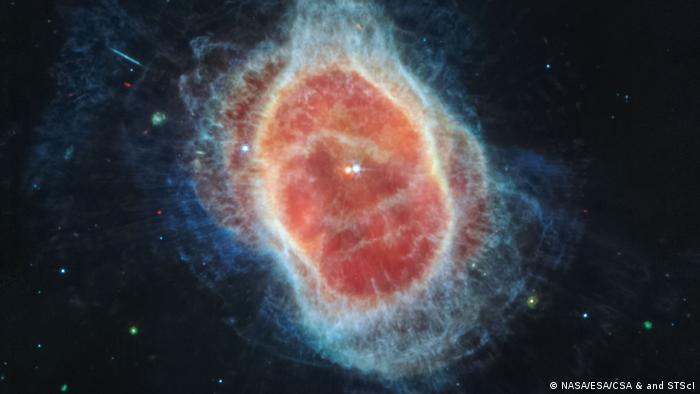 El telescopio James Webb ha revelado por primera vez el manto de polvo que rodea a la segunda estrella, mostrada a la izquierda en rojo, en el centro de la nebulosa del anillo sur.