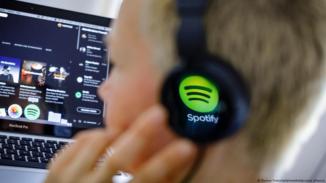 A man listens through Spotify-branded headphones to music on the music platform