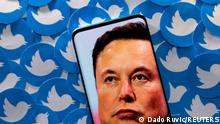 FILE PHOTO: An image of Elon Musk is seen on smartphone placed on printed Twitter logos in this picture illustration taken April 28, 2022. REUTERS/Dado Ruvic/Illustration//File Photo