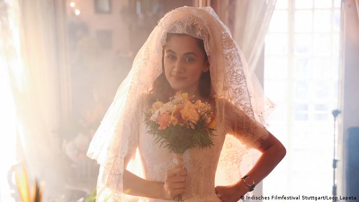 Film still 'Loop Lapeta': A bride holding a bouquet of flowers.