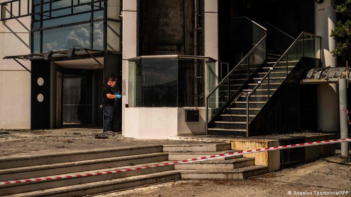 A Greek police expert investigates after firebombs exploded at Greece's Real News and Real FM radio facilites in Athens