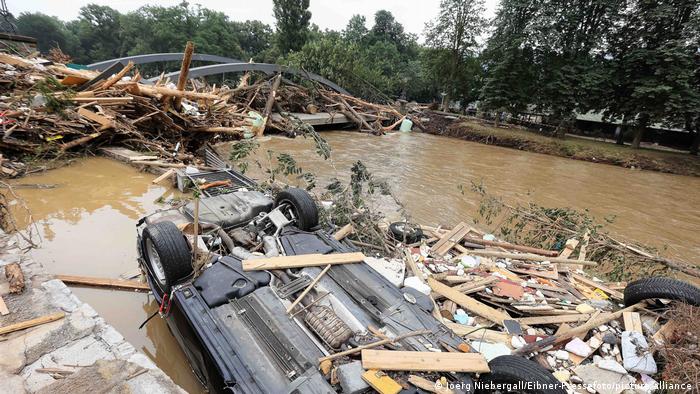Zerstörte Brücke und ein umgedrehtes Auto in einem Fluss im Ahrtal 2021