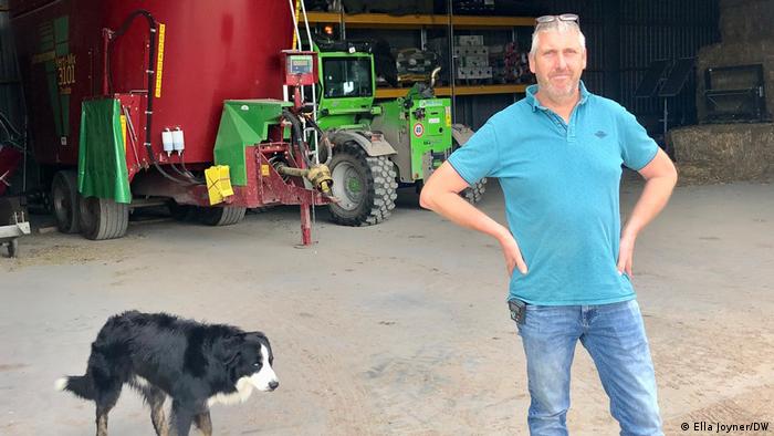 El agricultor Ad Baltus junto a su perro delante de sus tractores. 