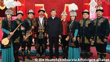 In this photo released by China's Xinhua News Agency, Chinese President Xi Jinping, center, poses for a photo with performers of the Manas, a cultural epic of the Kyrgyz people, at the Museum of the Xinjiang Uyghur Autonomous Region in Urumqi in northwestern China's Xinjiang Uyghur Autonomous Region, Wednesday, July 13, 2022. (Xie Huanchi/Xinhua via AP)
