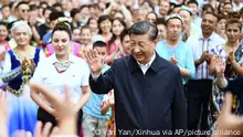 In this photo released by China's Xinhua News Agency, Chinese President Xi Jinping, center, visits the community of Guyuanxiang in the Tianshan District in Urumqi in northwestern China's Xinjiang Uyghur Autonomous Region, Wednesday, July 13, 2022. (Yan Yan/Xinhua via AP)
