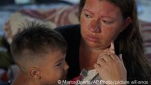 Venezuelan Jenny Villamizar, and her 3-year-old Santiago, who are part of a migrant caravan, sit inside a sports complex turned into a makeshift shelter, in Huixtla, Chiapas state, Mexico, Wednesday, June 8, 2022. The mother and son are part of an extended family of 18, including eight children, who traveled from Venezuela to Mexico’s southern border in 15 days. Venezuelans make up a large proportion of this caravan, the biggest of the year, in contrast to others in previous years. (AP Photo/Marco Ugarte)