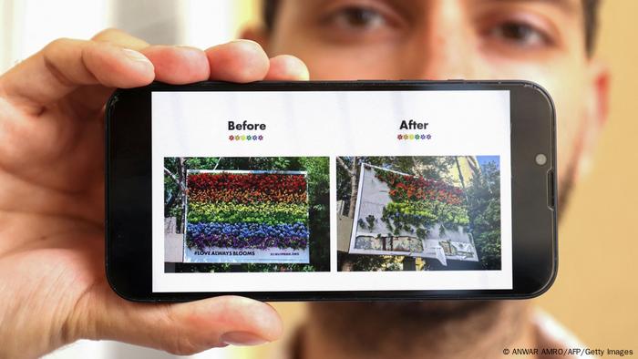 Hadi Damien, 33, the initiator of Beirut Pride, shows pictures on his telephone of a billboard featuring blooming flowers in the colors of a rainbow flag, before and after it was destroyed