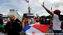 A man flutters a Panamanian flag on top of a truck as the Pan-American highway remains blocked in Chame, Panama, on July 14, 2022. - Panama's government is facing continuous protests against rising inflation and corruption. Demonstrations called by the Central American country's numerous unions have been taking place for the last two weeks, during which some main highways were blocked. (Photo by ROGELIO FIGUEROA / AFP) (Photo by ROGELIO FIGUEROA/AFP via Getty Images)