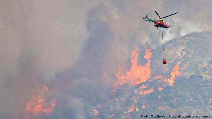 A helicopter flies over a fire near Malaga