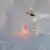 A water bombing aircraft flies over the Sierra de Mijas forest fire in Spain