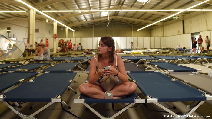 A tourist sits on a bed in an evacuation center