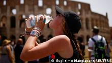 A girl drinks water near the Colosseum as an extraordinary heatwave hits Italy, in Rome, June 27, 2022. REUTERS/Guglielmo Mangiapane