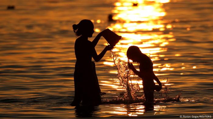 La ola de calor que azota a distintas regiones de Europa ha obligado a las personas a buscar soluciones rápidas que permitan hacer más llevaderas las jornadas. Italia, Francia, España, Alemania y otros países han registrado temperaturas de hasta 45 grados Celsius. En Albania, dos niños se refrescan al ocaso, intentando dar un toque fresco al final del día.
