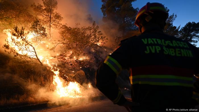 Um bombeiro assiste a um incêndio em Sibenik, Croácia