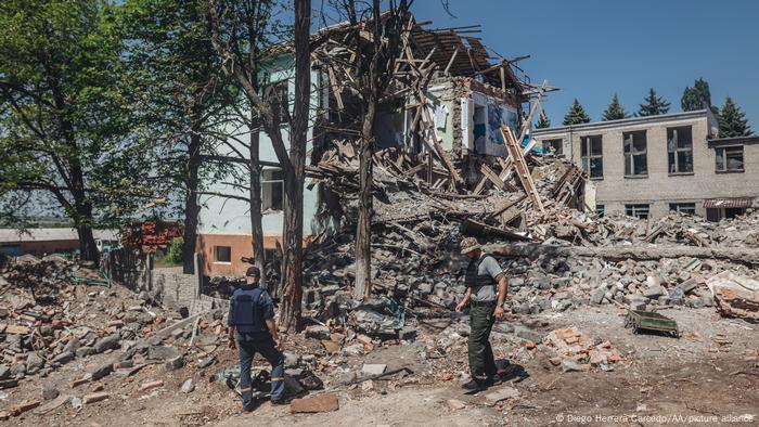 Dos hombres examinan un edificio bombardeado en Siversk, Donetsk Oblast, una zona sometida a múltiples ataques armados de Rusia.