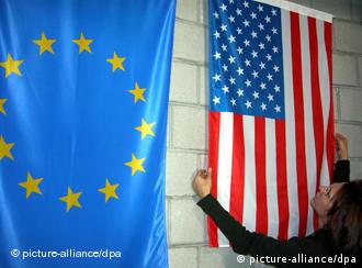 Женщина поправляет флаг США, висящий рядом с флагом ЕС