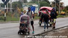 Venezuelan migrants walk on the Pan-American Highway after crossing the Ecuadorian border, in Tumbes, Peru, Friday, Jan. 29, 2021. (AP Photo/Martin Mejia)