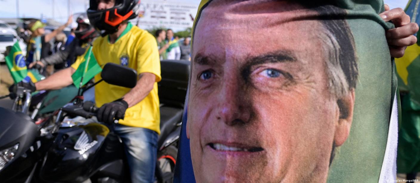 Carreata de motocicletas. Em primeiro plano, costas de camiseta com rosto de Jair Bolsonaro