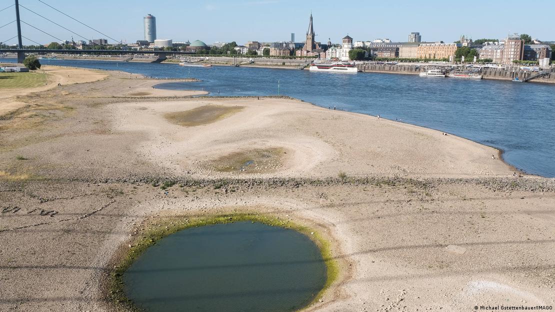 Banco de areia em rio, com cidade ao fundo
