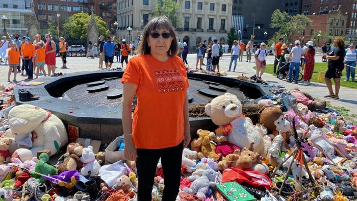 Evelyn Korkmaz surrounded by toys at a memorial