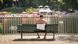 Homem sentado de costas em um banco na orla do rio, sem camisa Homem sentado de costas em um banco na orla do rio, sem camisa