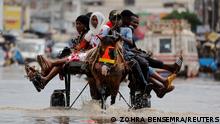 Residents make their way through a flooded street after heavy rains in Yoff, district of Dakar, Senegal July 20, 2022. REUTERS/Zohra Bensemra TPX IMAGES OF THE DAY 