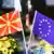 The flags of North Macedonia (left) and the EU are seen in a glass on a table with flowers in the background, Skopje, North Macedonia, July 20, 2022