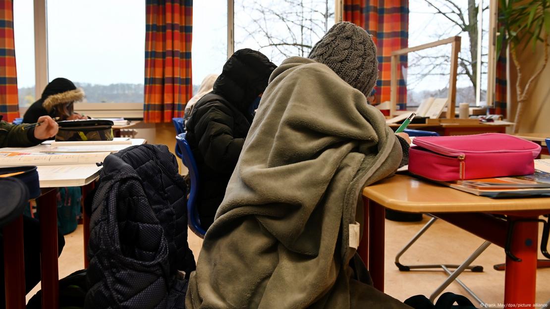 Mališani u zimskim kaputima i pokriveni dekama u učionici uz otvorene prozore u studenom 2020.