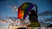 A dancer of the cheerleading team dances with a rainbow flag at the Gran Muthu Rainbow Hotel located Guillermo Key in Ciego de Avila Province, Cuba on November 27, 2021. - Cuba's first LGBT hotel, which had been inaugurated in December 2019, but very soon had to close due to the coronavirus pandemic, reopened to attract that tourist segment at a time when authorities are studying the approval of equal marriage on the island. Under all preventive sanitary measures, this five-star accommodation received its first clients again on November 15, when Cuba reopened its borders after 10 months of confinement. (Photo by YAMIL LAGE / AFP) (Photo by YAMIL LAGE/AFP via Getty Images)
