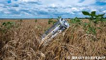 A fragment of a rocket from a multiple rocket launcher is seen embedded in the ground on a wheat field in the Ukrainian Kharkiv region on July 19, 2022, amid Russian invasion of Ukraine. - Russia and Ukraine on July 22, 2022 signed a landmark deal with the United Nations and Turkey on resuming grain shipments that could ease a global food crisis in which millions face hunger. (Photo by SERGEY BOBOK / AFP)