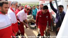 In this photo provided by the Iranian Red Crescent Society on Saturday, July 23, 2022, members of a rescue team load the body of a victim to an ambulance after Friday's flash floods in Iran's drought-stricken southern Fars province, Iran. Heavy rains swelled the Roudbal river by the city of Estahban, according to the city's governor Yousef Karegar. (Iranian Red Crescent Society via AP)