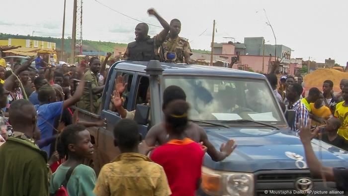 Malian soldiers are cheered by the population as they enter a military camp in Kati