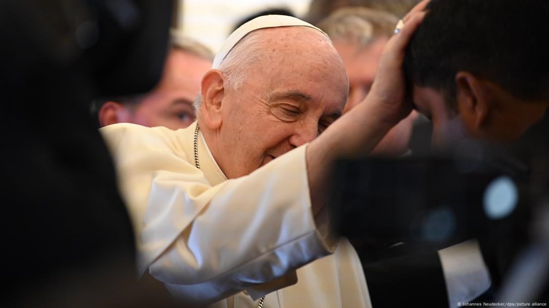 Papa com a mão na cabeça de um homem