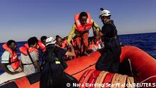 Sea-Watch crew member helps a migrant boarding a dinghy in the Mediterranean Sea, July 23, 2022. Nora Bording/Sea-Watch/Handout via REUTERS ATTENTION EDITORS - THIS IMAGE HAS BEEN SUPPLIED BY A THIRD PARTY. MANDATORY CREDIT
