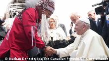 Papst Franziskus (r) wird von George Arcand, Großhäuptling der Confederacy of Treaty Six First Nations, nach seiner Ankunft auf dem internationalen Flughafen von Edmonton empfangen. Der Papst will sich in Kanada nach dem Fund Hunderter Leichen nahe ehemaligen von der katholischen Kirche geführten Internaten bei der indigenen Bevölkerung für jahrzehntelangen Missbrauch entschuldigen. +++ dpa-Bildfunk +++