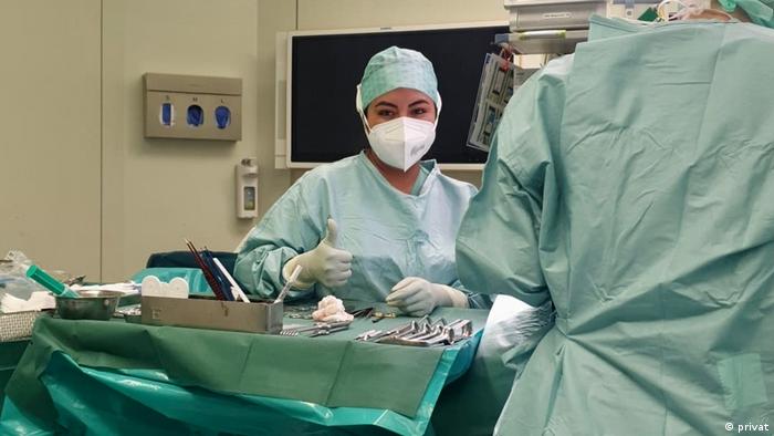Eine operationstechnische Assistentin aus Mexiko steht in einer Klinik im Operationssaal und hält den Daumen der rechten Hand hoch.