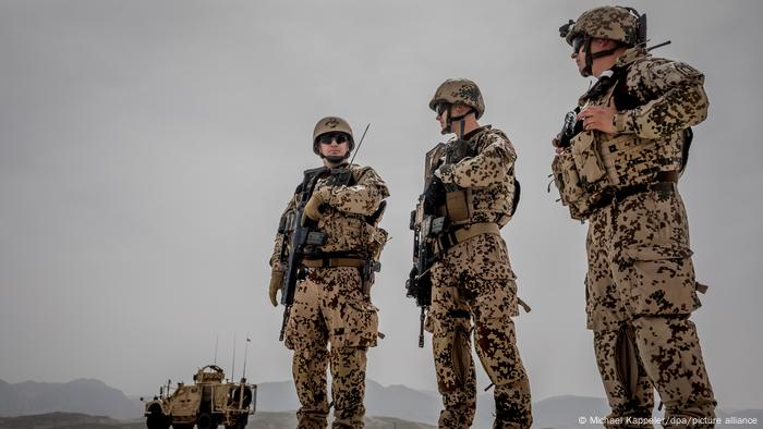 Bundeswehr-Soldaten mit Maschinengewehren und schusssicheren Westen bewachen einen Militär-Konvoi in Afghanistan. Bundeswehr-Soldaten mit Maschinengewehren und schusssicheren Westen bewachen einen Militär-Konvoi in Afghanistan.