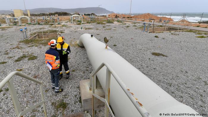 Zwei Männer stehen neben einer Erdgas-Pipeline am Mittelmeer 