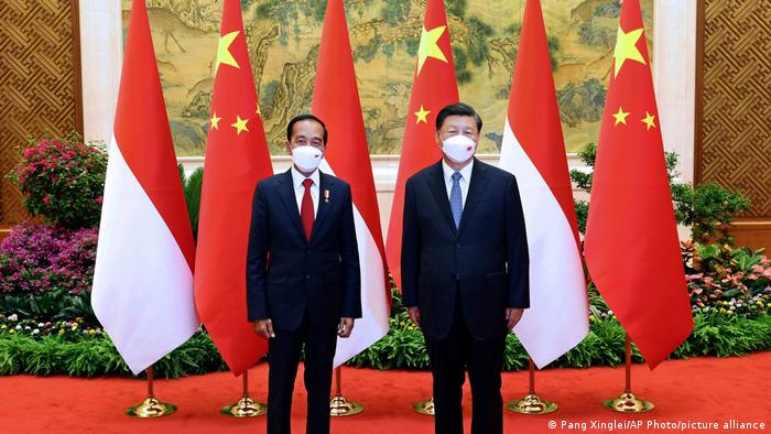 Indonesian President Joko Widodo (L) and Chinese President Xi Jinping (R) standing in front of their national flags