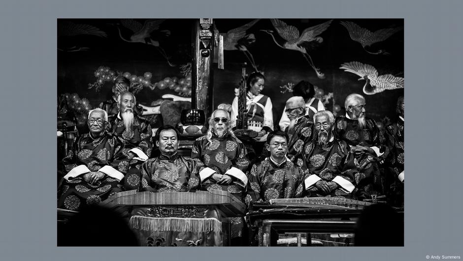 Andy Summers Ausstellung A Certain Strangeness in Wetzlar: Eine Gruppe chinesischer Männer posiert vor einem Hintergrund mit Phantasie-Vögeln.