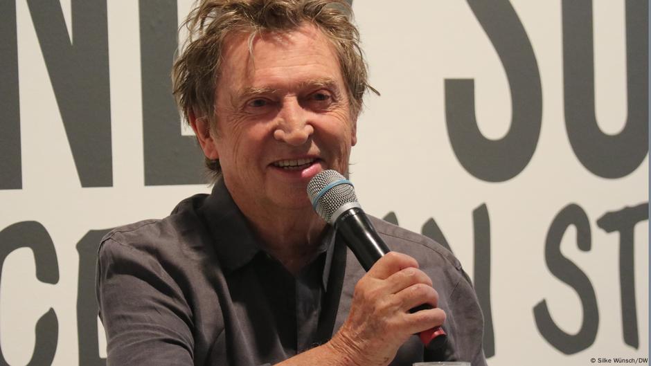 Andy Summers at A Certain Strangeness speaking i nto a microphone