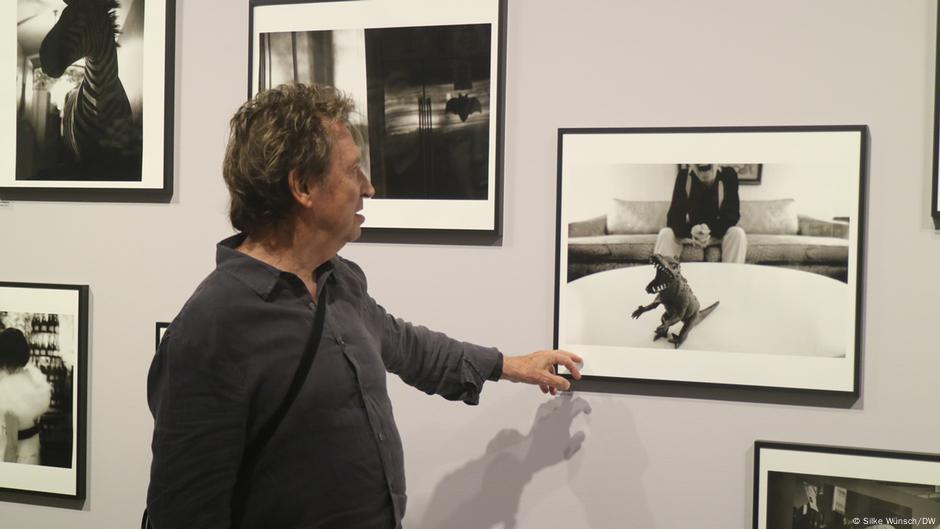 Andy Summers zeigt auf ein Bild mit einem Gummi-Dinosaurier.