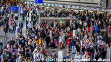 Passengers queue at check in counters at the international airport in Frankfurt, Germany, Wednesday, July 27, 2022. Lufthansa went for a 24-hours-strike on Wednesday, most of the Lufthansa flights had to be cancelled. (AP Photo/Michael Probst)