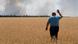 A farmer in Ukraine reacts as he looks at his burning field A farmer in Ukraine reacts as he looks at his burning field