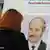 Избиратель читает информацию о кандидате в президенты Лукашенко