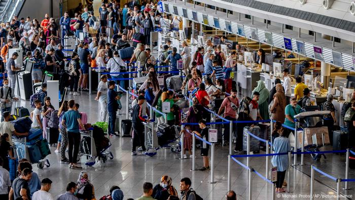 Passengers queue at check in counters at the international airport in Frankfurt, Germany, Wednesday, July 27, 2022.