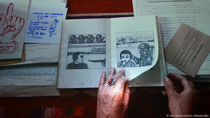 Woman's hand turning page of a book with drawings