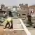 عامل يمني يحاول إصلاح سطح أحد المنازل في العاصمة صنعاء، يوليو/ تموز 2022