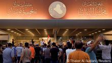 People hold their cell phones outside of the parliament building as supporters of Iraqi Shi'ite cleric Moqtada al-Sadr protest against corruption inside, in Baghdad, Iraq July 27, 2022. REUTERS/Thaier Al-Sudani