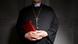 a priest in a church, holding a bible a priest in a church, holding a bible